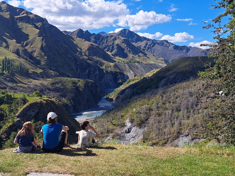 Kids on our New Zealand Family Vacation taking a break in the beautiful scenery near Queenstown